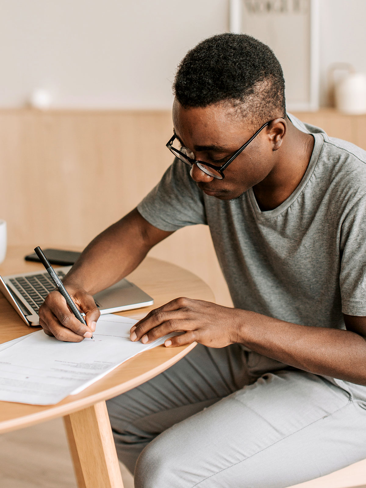 Young engineer signing a job offer on a table.