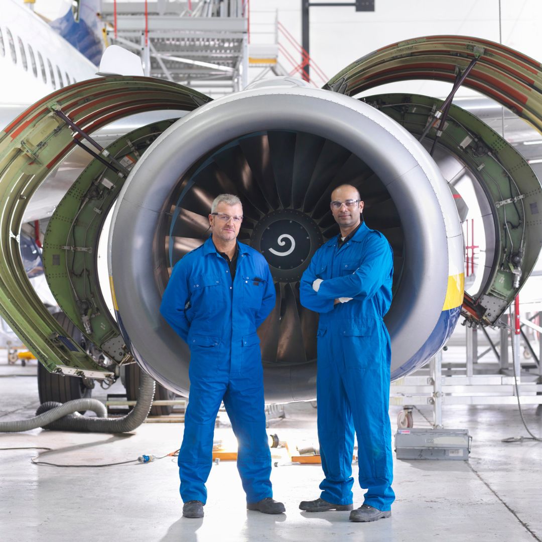 Aircraft engineers in front of a 737 jet engine.