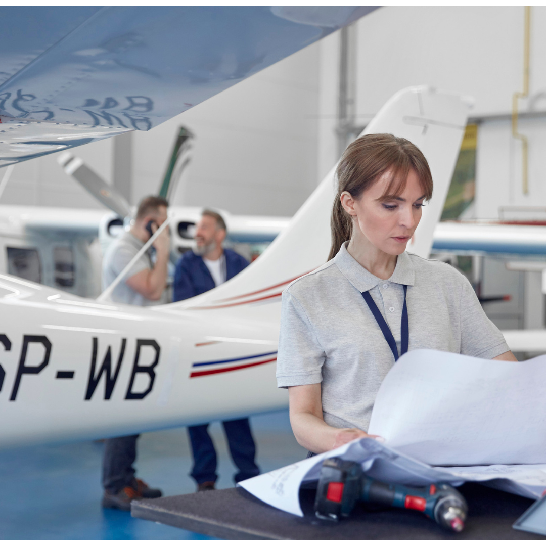 Aerospace engineer reviewing plans in front of a plane.