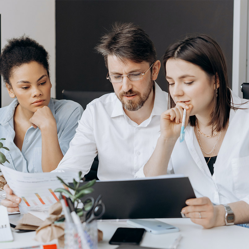Three engineers discussing design plans.